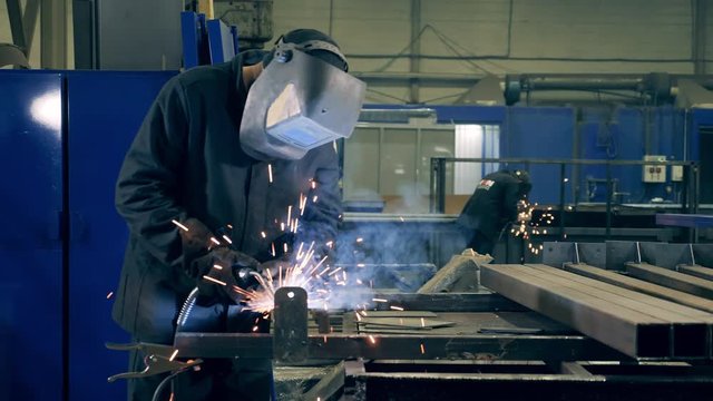 Welding technician is brazing pieces of metal. Professional Welder Working at factory facility.
