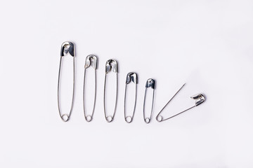 Collection of pins of different sizes on a white background.