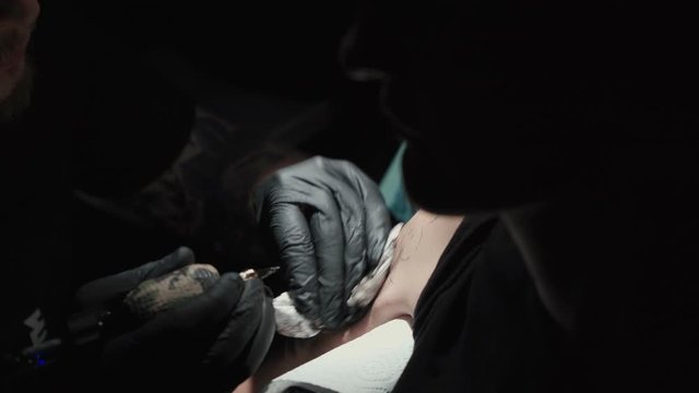 Footage of man doing tattoo for woman in studio