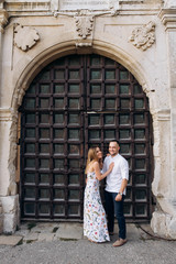Fototapeta na wymiar Young couple in love outside on old castle portal background