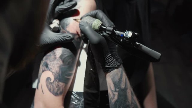 Footage of man doing tattoo of snake for woman