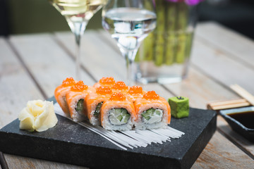 Traditional rolls with fish and rice on a white plate with sauce and wasabi. Japanese food.
