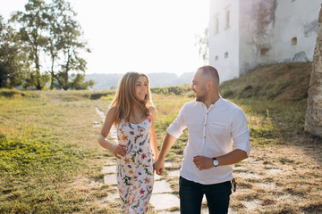 Candid photo of happy laughing young couple enjoy life together with natural outdoor laisure activity lifestyle outside during the summer and the sunset in backlight