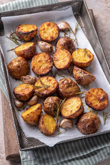 Roasted potato with rosemary on a baking sheet