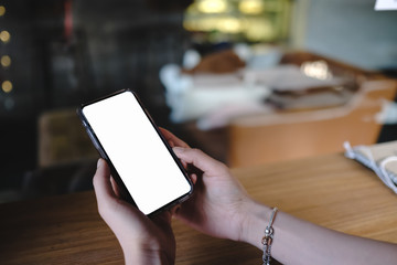 Close up of woman using cell phone,sending massages on the coffee shop.having sunbath.Phone with black screen,texting,video calls,