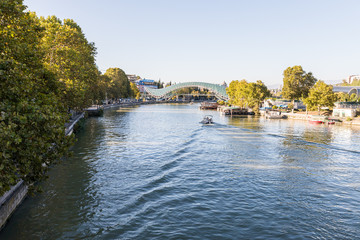 Fototapeta na wymiar The Mtkvari river and the Bridge Of Peace in Tbilisi city in Georgia