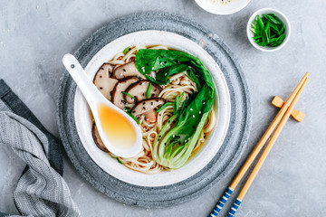 Asian Vegetarian Udon or Ramen noodles soup in bowl with Shiitake mushrooms and Bok Choy