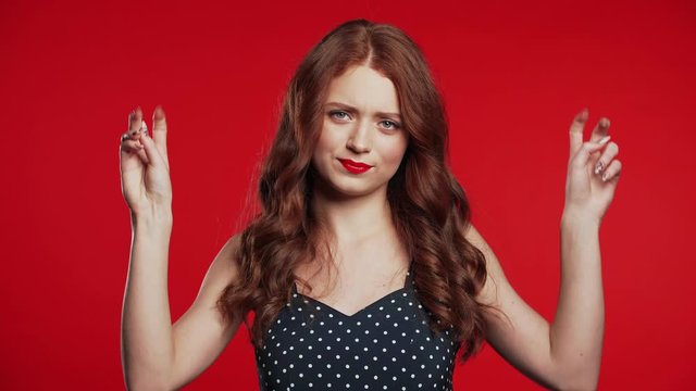 Pretty girl showing with hands and two fingers like quotes gesture, bend fingers isolated over red background. Very funny, irony and sarcasm concept.
