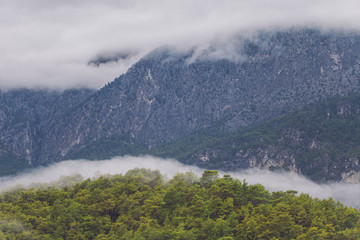 Tops of mountains and cloudy rainy sky over hills.