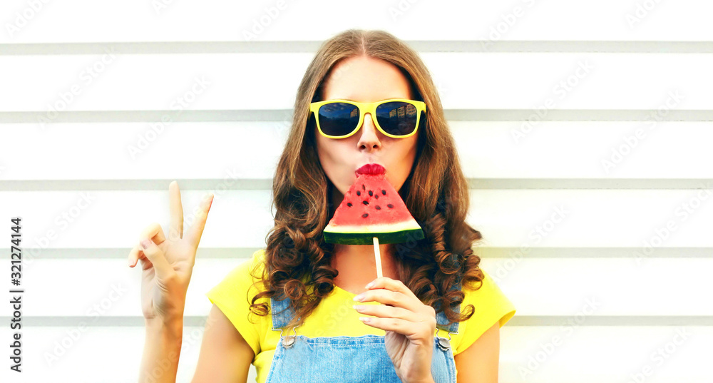 Wall mural portrait young woman eating ice cream shaped watermelon over white background