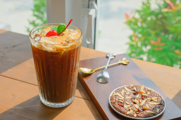 Homemade biscuit brownie with Iced americano coffee for Breakfast on Wooden table.