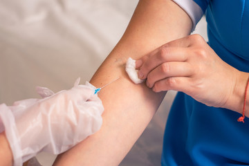 A nurse injects a colleague into a vein. The concept of vaccination against dangerous diseases. Injection into a vein is a close-up.