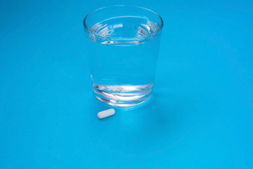 Glass of water, a pill, a medicine for a headache. Virus. Flu. Quarantine. Treatment, cold concept.