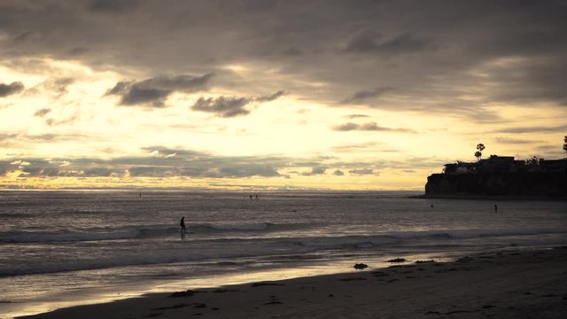 Surfers on waves at golden hour, beautiful sunset on the beach