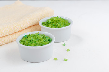 The concept of spa treatment, with natural, fragrant two-tone, sea bath salt and bath towels. On a white background