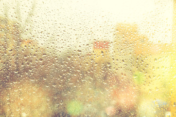 Blurred rainy view of the city through a wet window with raindrops