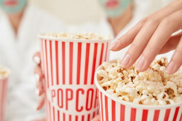 Selective focus of popcorn boxes in female arms.