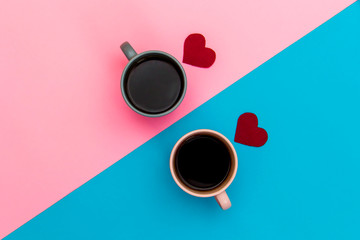 Pink and blue cups of coffee stand on a two-color pink-blue background, next to red lie hearts. Minimalism with coffee. Breakfast Tea for Valentine's Day, Mother's Day, 8 of March. Place for text