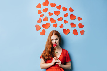 redhaired lady radiating love isolated over blue background. woman glows with happiness, small...
