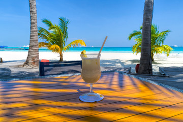 A glass of cold cocktail on a table on the beach in a restaurant