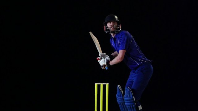 Cricket Batsman Hitting The Ball - Cut Shot. Black Background. Dressed In Blue. Limited Overs.