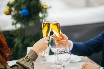 close-up of couple clinking glasses with champagne in rich representative restaurant. couple having dinner together, on a date