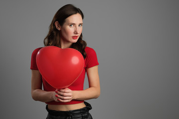 Beautyful emotional brunette girl with red balloon