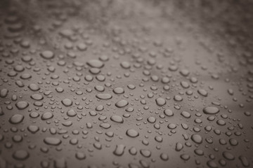 hundreds and thousands of beaded water droplets on a gloss Brown color surface.