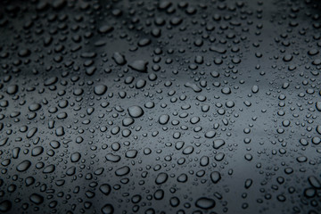  hundreds and thousands of beaded water droplets on a gloss black surface