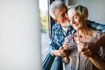 Happy senior couple in love hugging and bonding with true emotions at home