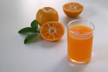 orange juice in a glass on a white table