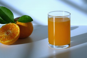 orange juice in a glass on a white table with morning light