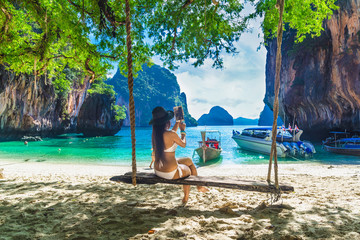 Beautiful nature scenic landscape Lao Lading island beach, Traveler girl in bikini on swing using...