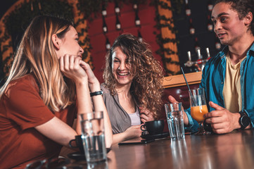 Group of friends enjoying in cafe together, talking and drinking coffee.