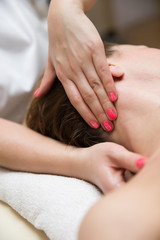 Woman getting a stress relieving pressure point massage on her neck by a health therapist