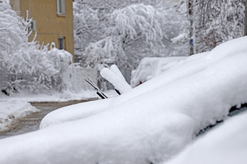Cars covered with heavy snow after snowstorm in winter