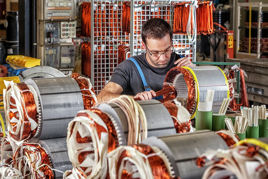 Skilled industrial worker assembling electric motors
