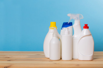 Cleaning product plastic container for house clean on wooden table and blue background . household chemicals