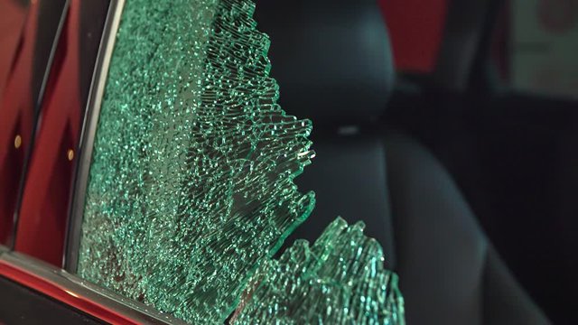 A broken window and a car are in a repair shop.