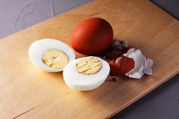 chopped chicken egg whole chicken egg and eggshell on a cutting board