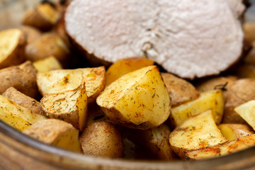 A piece of juicy meat and potatoes baked in a glass bowl