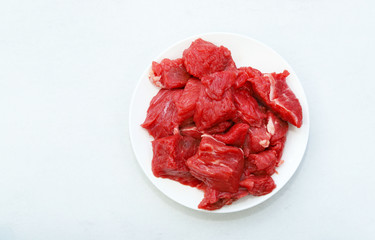 Raw meat on white plate.