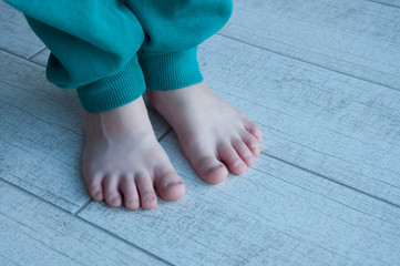 Legs of a young child in green pants. Close-up