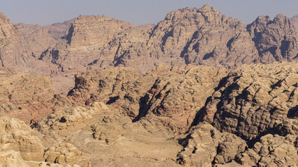 View of ancient Petra from above. Red mountains of Jordanian desert inside which ancient city Petra was carved into stone. Ecology and travel theme. There is place for your text. Petra, Jordan - 2011