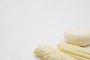 Types of cheese, including pigtail, hard and white round, are isolated on a white background. Concept white cheeses or natural dairy products rich in calcium.