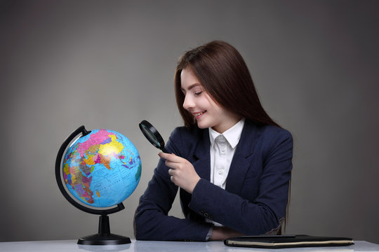 schoolgirl looking at globe.Geography