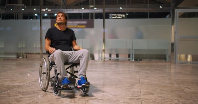 Disabled young man in wheelchair on an airport.