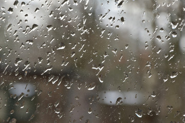 Fototapeta Krople deszczu na szybie, w tle nieostry zarys domu. obraz