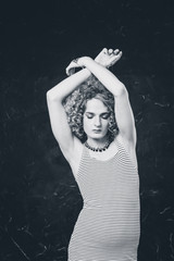 Black and white portrait a young man androgyne in the image of a woman in a dress stinging dress....