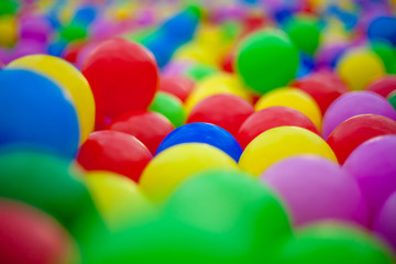 Close-up of multi-colored bright round plastic balls in large numbers. Background for children's holiday. Children's birthday